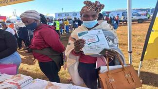 Sassa social grant beneficiary carrying  her Sassa gold payment card 