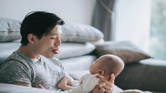 A new father with his baby while on paternity leave.