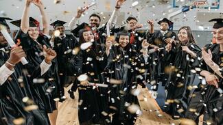 graduates celebrating in gown and caps