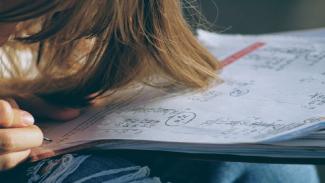Student writing in a book