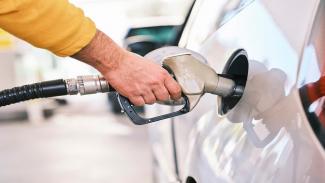 person filling up car with petrol