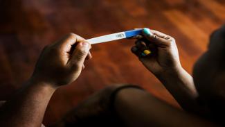 woman looking at a pregnancy test